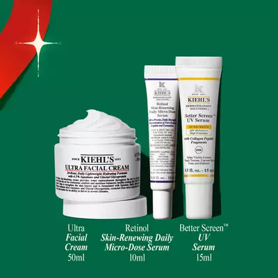 A Kiehl's holiday gift set featuring Ultra Facial Cream, Retinol Serum, and UV Serum, displayed alongside a festive red ribbon and promotional price tag.