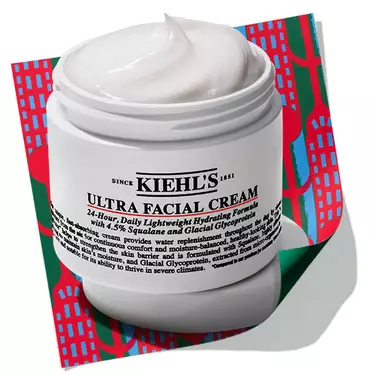 Open jar of Kiehl's Ultra Facial Cream set against a holiday-themed patterned background.​